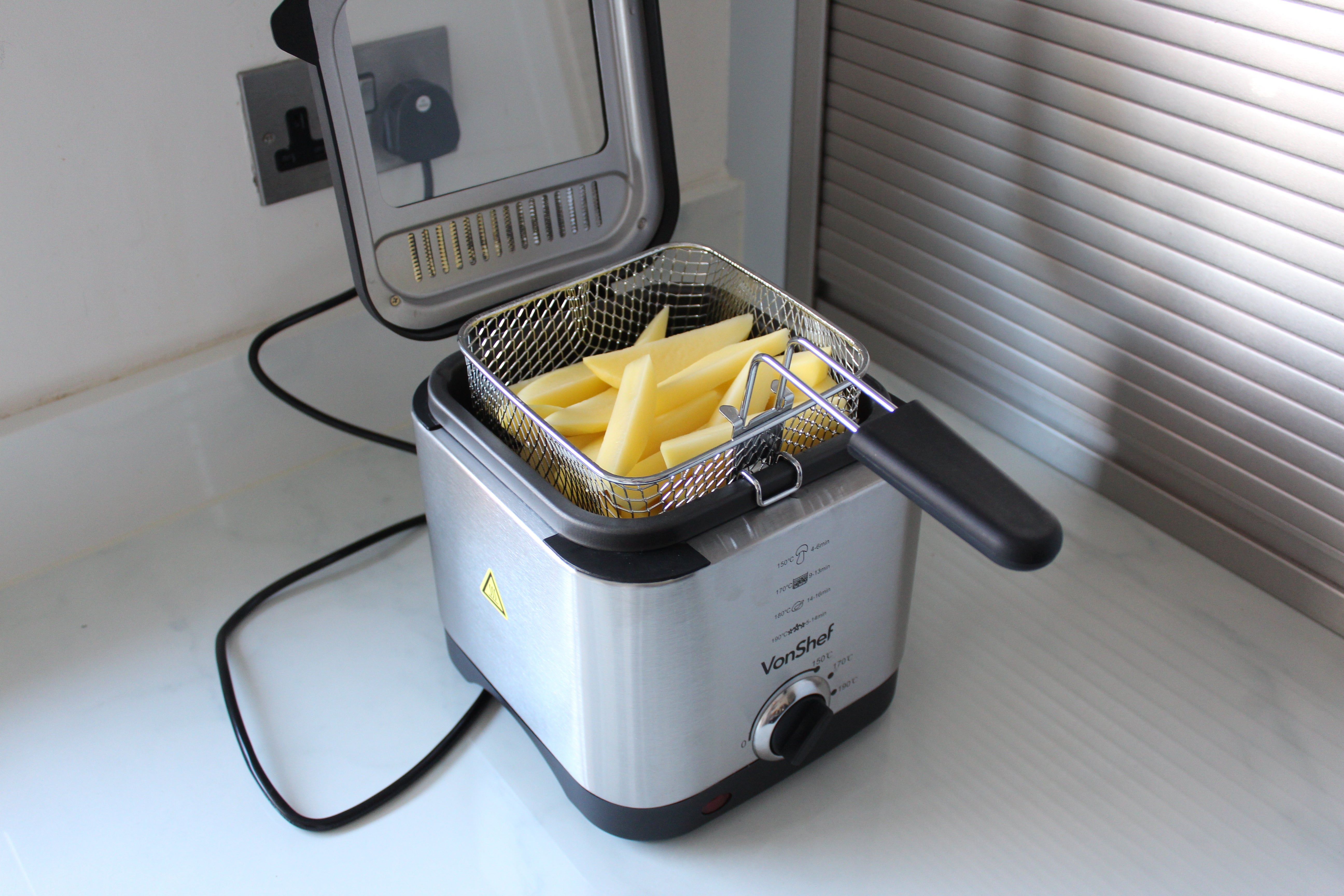VonShef 1.5L Deep Fat Fryer on counterA silver-black VonShef deep fat fryer kept on a kitchen platform with raw French fries kept insideRight angled view of a silver-black VonShef deep fat fryer kept on white background with raw French fries kept insideA silver-black VonShef deep fat fryer kept on a white background