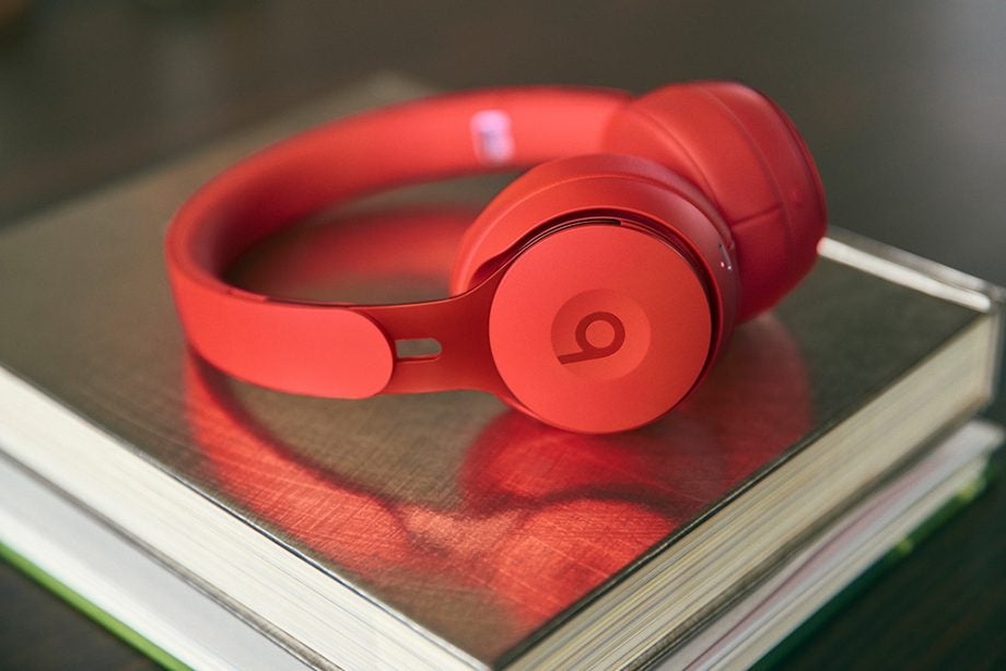 Right side view of red Beats Solo Pro headphones laid on book on a table