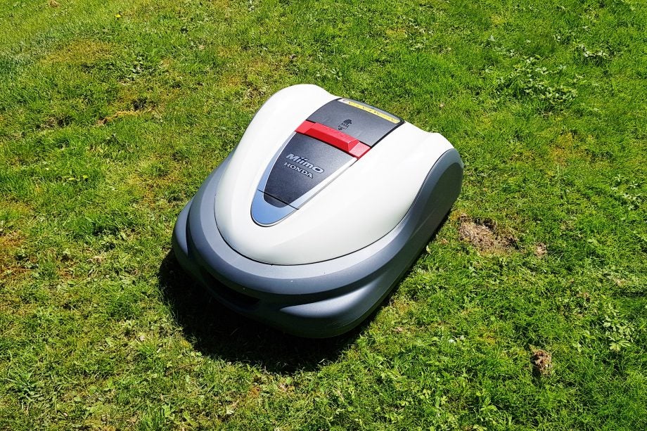 A gray-white Honda Miimo 3000 robot lawnmower standing in a lawn