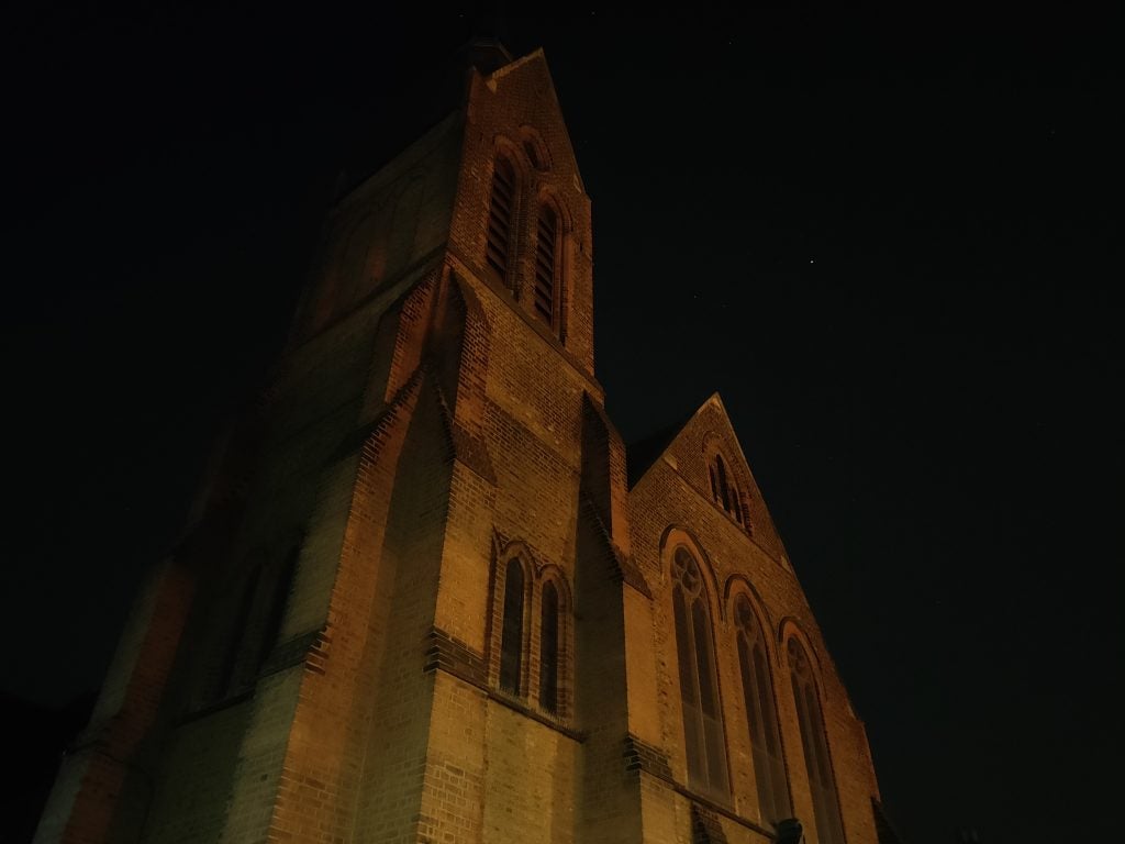 A big church with brick texture taken from bottom to top view, picture taken at night, partially clear