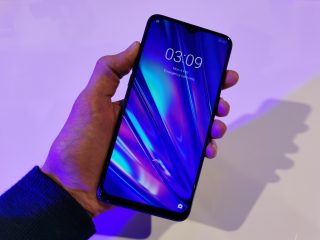 A Realme 5 Pro held in hand displaying lockscreen