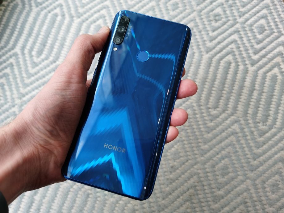 Back panel view of a blue Honor 9X held in hand facing back