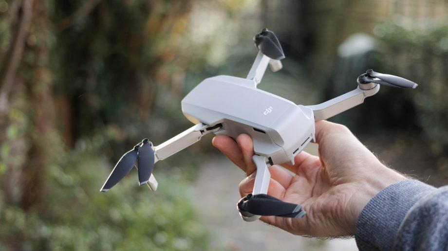 Left angled view of a silver-white Mavic Mini held in hand