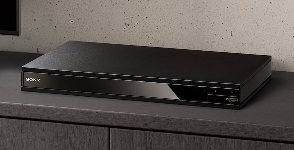 The Sony UBP-X800M2 4K Blu-ray player's design is fairly angular.Right half view of a gray-black Sony X800M2 player kept on a white background with a USB drive connected to it