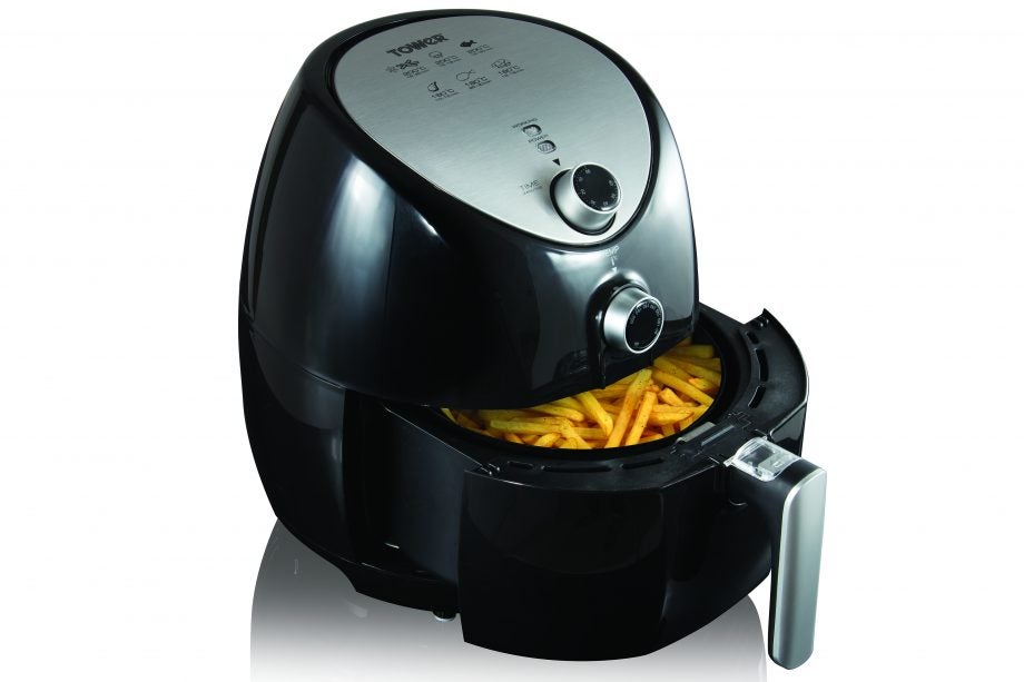 Left angled view of a black Tower 4.3L Air Fryer kept on a white background with fried French fries kept inside