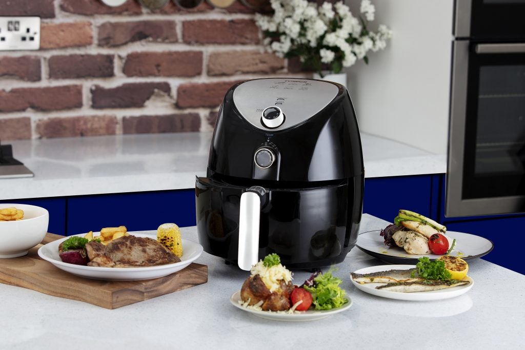 Right angled view of a black Tower 4.3L Air Fryer kept on a kitchen platform with foot kept around