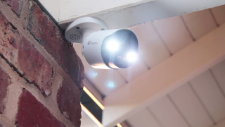 Close jup view of a Swann day/night 4K Spotlight NVR camera mounted to a roof edge in a corner