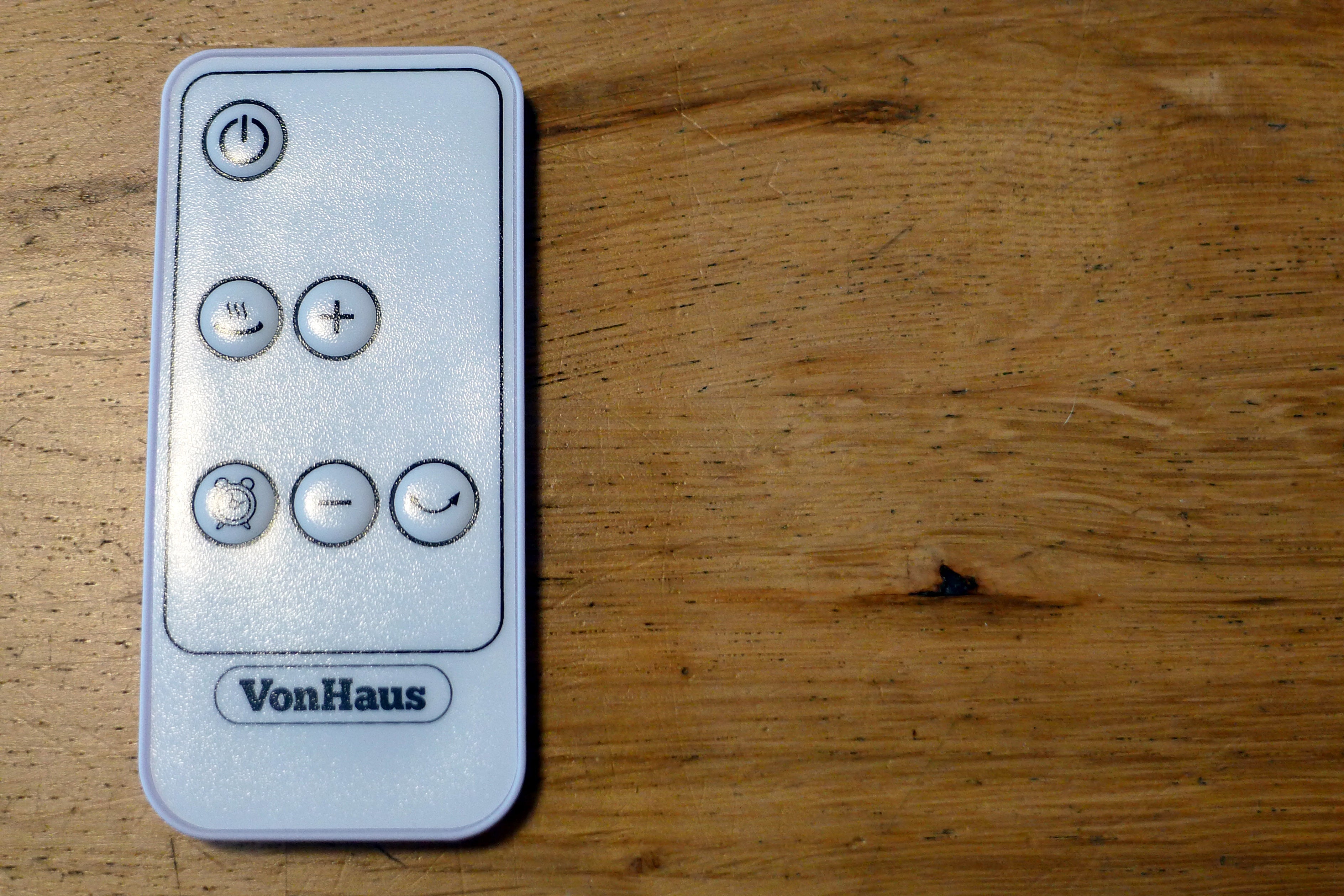 A white VonHaus fan heater's remote kept on a table