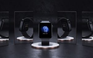 A black Mi Watch standing on a black background with mirrors around reflecting back and side views