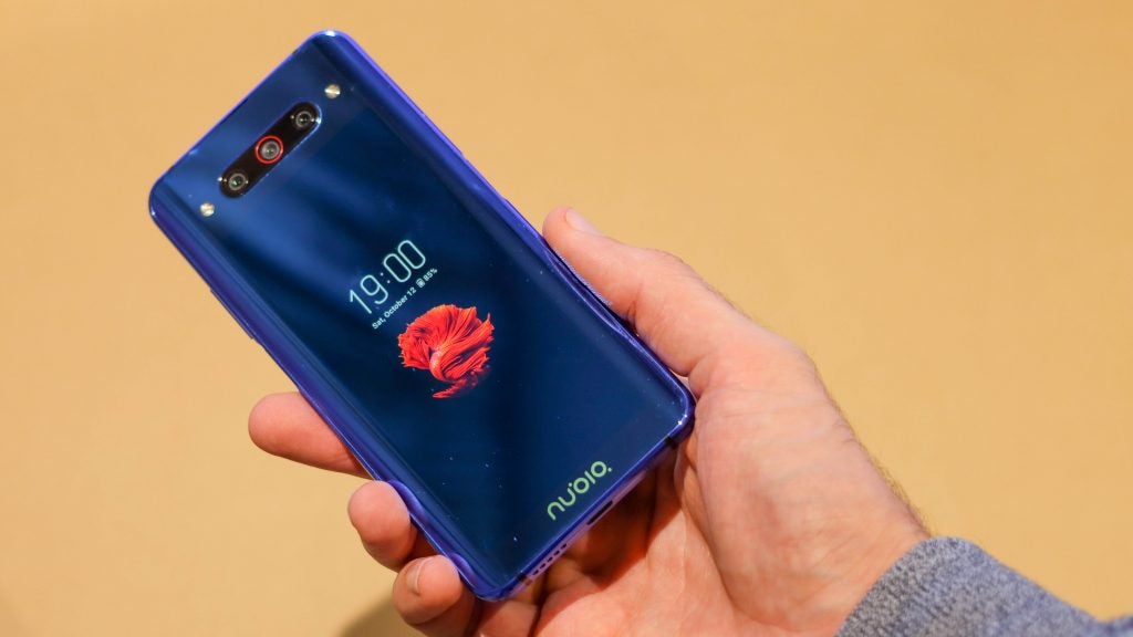 Back panel view of a ZTE Nubia Z20 held in hand with second screen on back panel displaying lock screen
