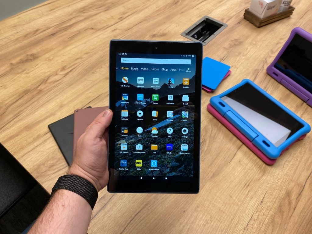 An Amazon Fire Kindle held in hand displaying home menu screen