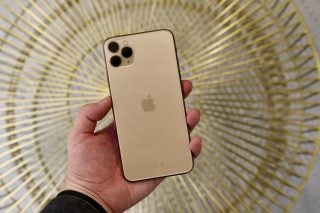 Back panel view of a golden iPhone 11 Pro Max held in hand facing back