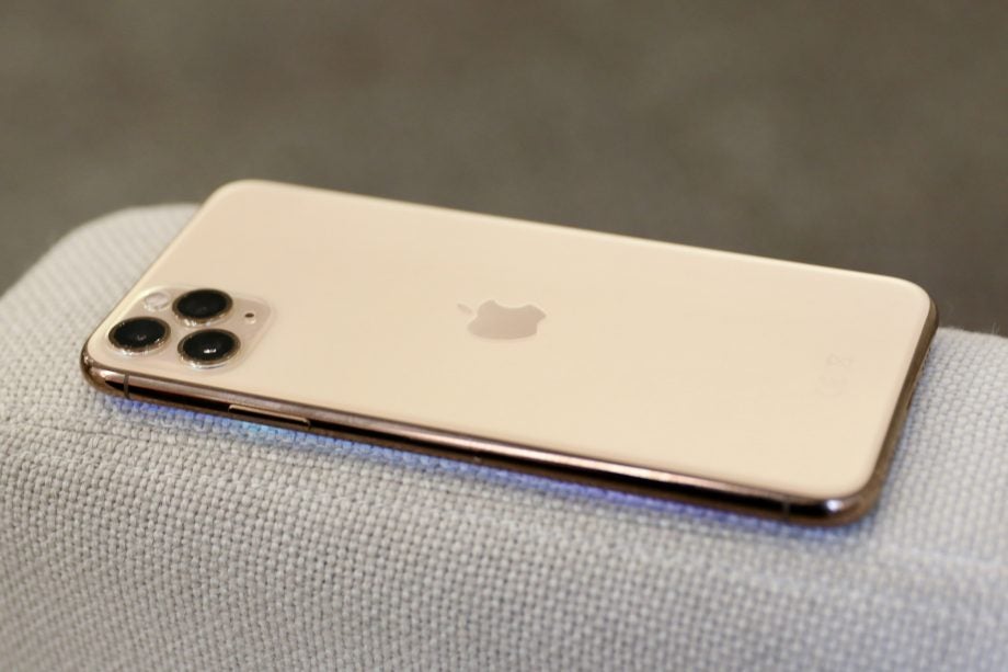 Right side edge view of an iPhone 11 Pro Max kept facing down on a couch's back wall