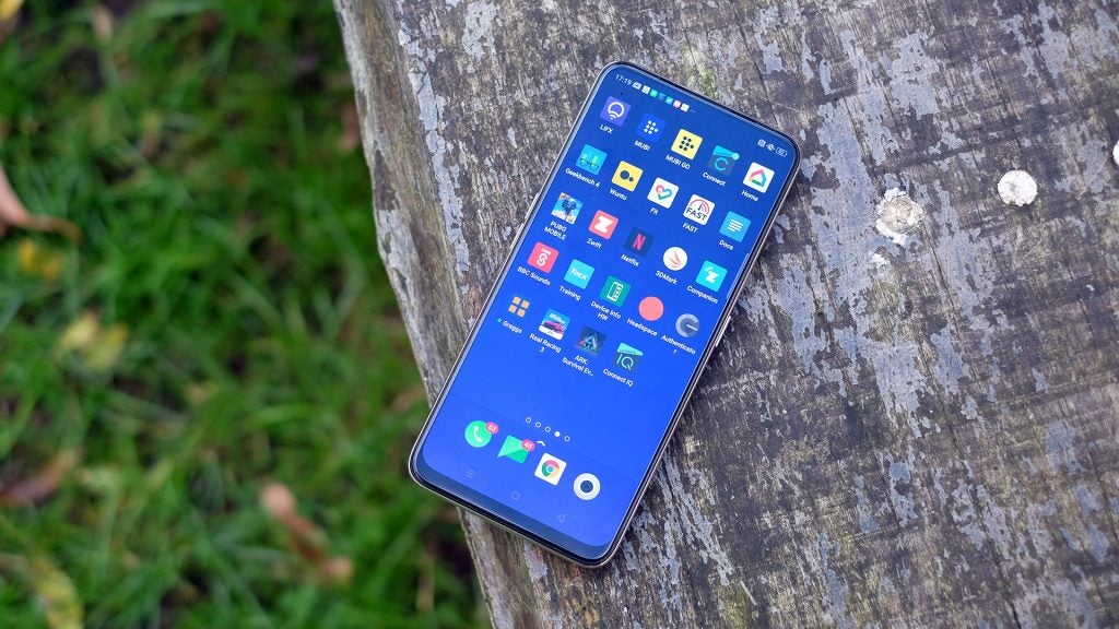 View from top of an Oppo Reno 2 Z kept on a wooden surface displaying homescreen