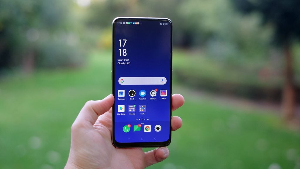 An Oppo Reno 2 Z held in hand displaying homescreen