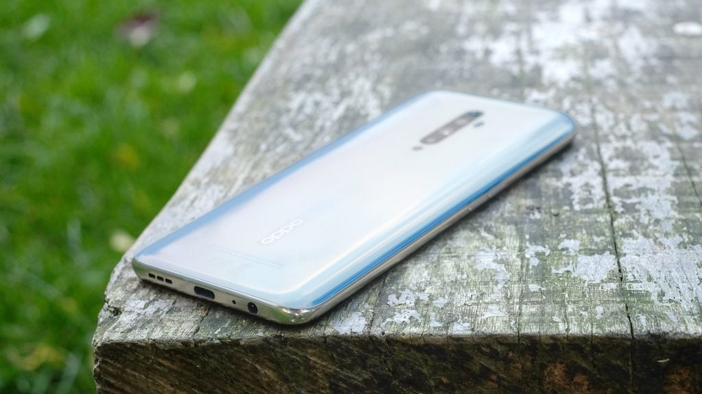 Bottom edge view of a light blue Oppo Reno 2 Z kept facing down on a wooden surface