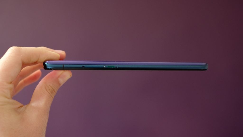 Right side edge view of a blue smartphone held in hand horizontally