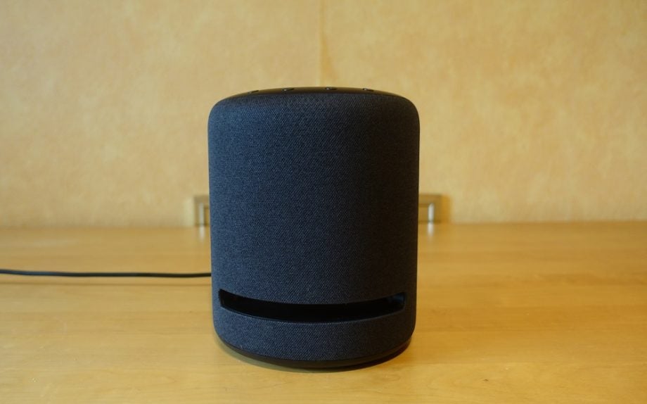 A black Echo Studio smart speaker standing on a table