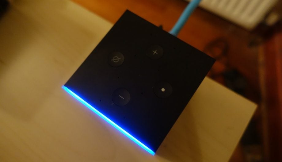 View from top of a black Amazon Fire TV Cube kept on a table with buttons on top