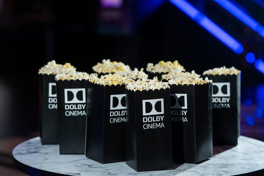 Black popcorn filled bags with Dolby Cinema logo on them kept on a table