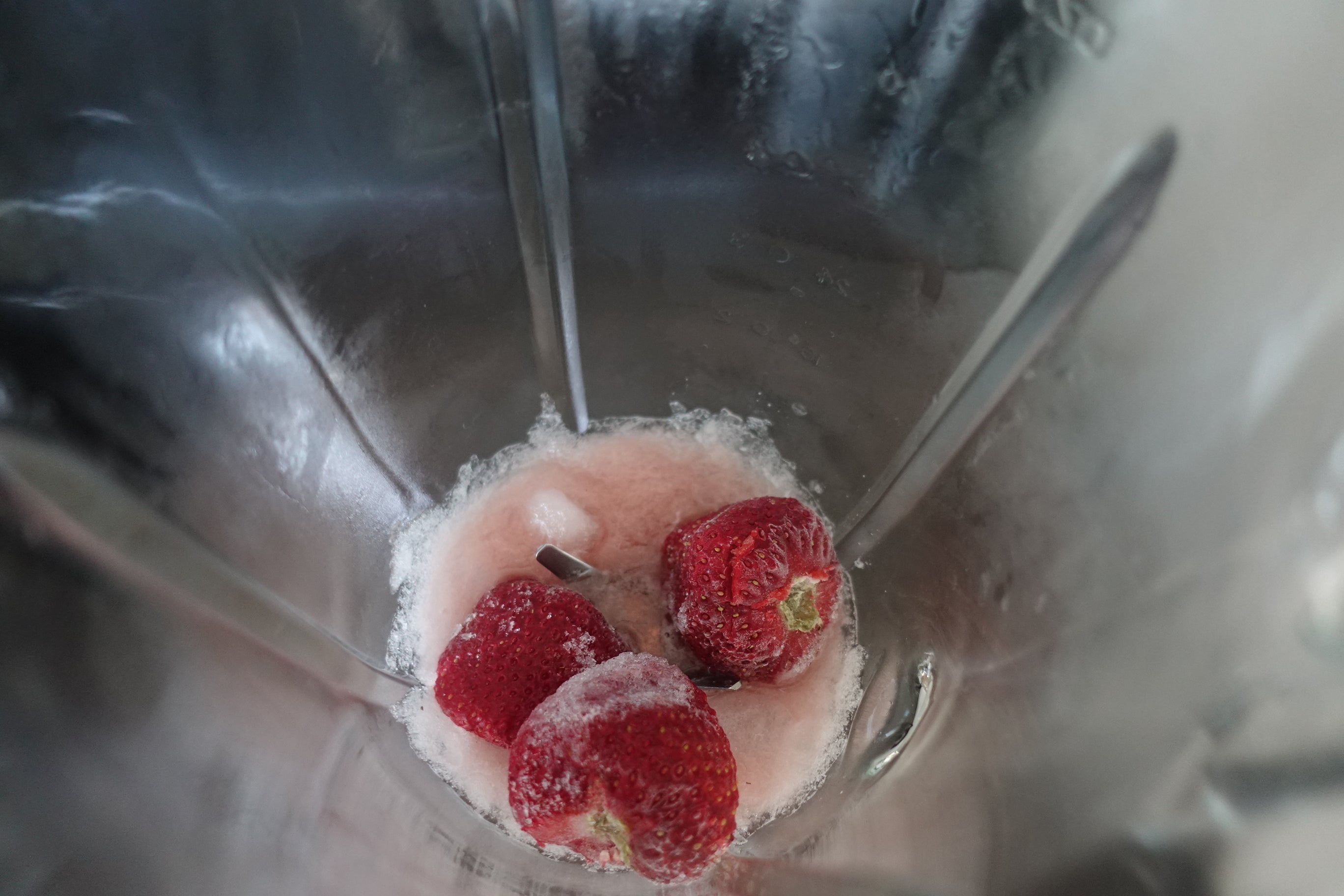 crushed ice in a blender with syrup and frozen strawberrys 
