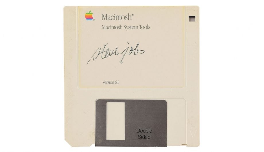 A cream colored signed Apple's floppy disk kept on a white background, bought from an auction