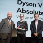 A woman receiving award from two men on stage, Dyson V11 displayed on screen behind, Trusted Reviews Awards