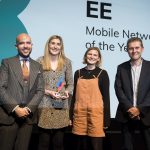 Two women receiving award from two men on stage, EE displayed on screen behind, Trusted Reviews Awards
