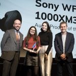 Two women receiving award from two men on stage, Sony WF1000 XM3 displayed on screen behind, Trusted Reviews Awards