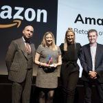 Two women receiving award from two men on stage, Amazon displayed on screen behind, Trusted Reviews Awards