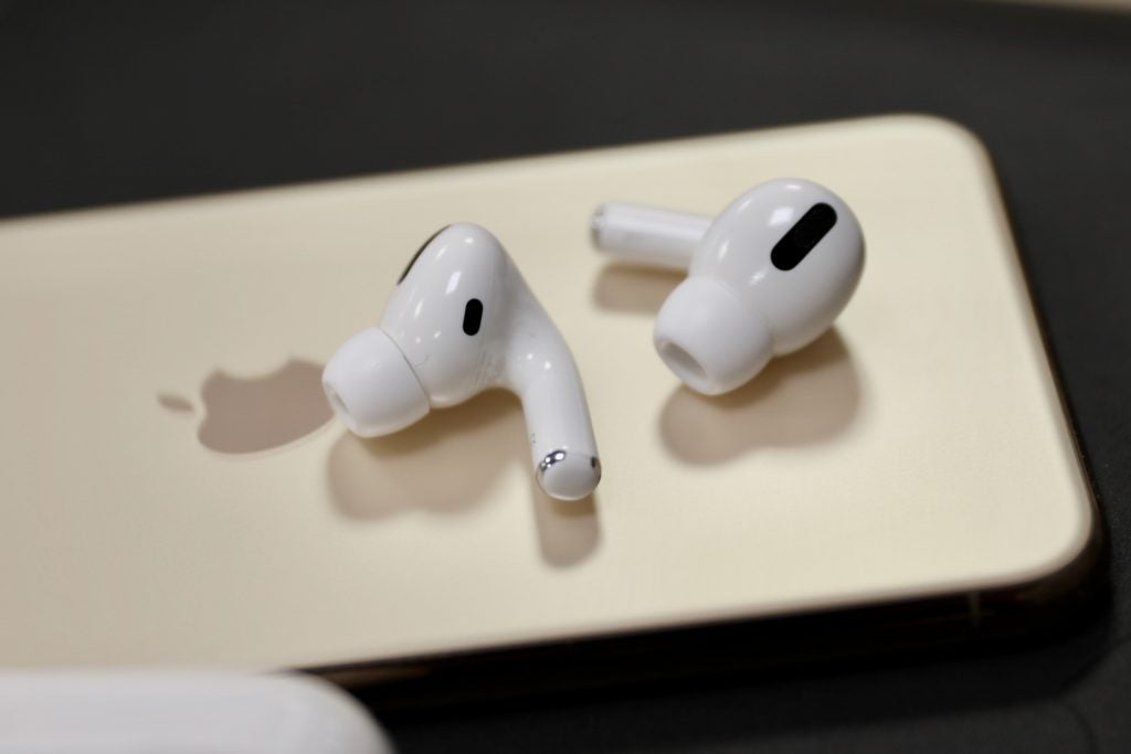 airpods proAirPods Pro resting beside it's case and an iPhone on a black tableAirPods Pro kept on an iPhone on a black table