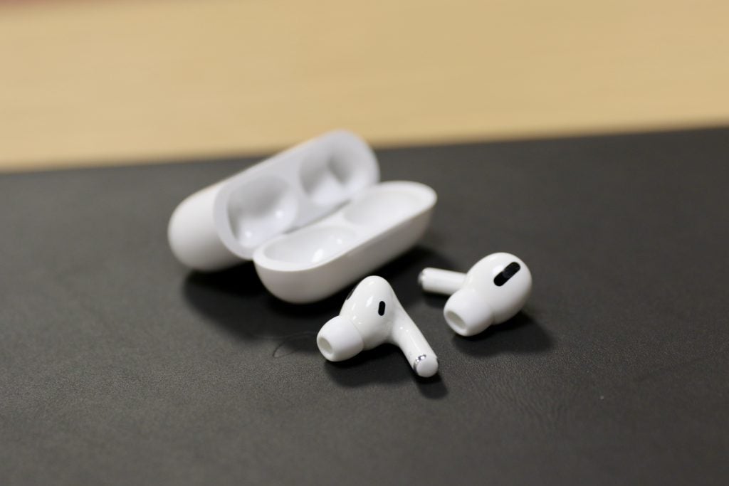 AirPods Pro next to case on a black table