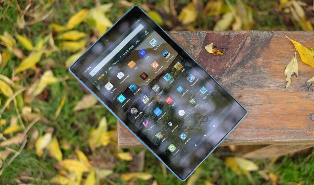 View from top of a Fire HD 10 tablet kept on a wooden surface displaying home menu screen