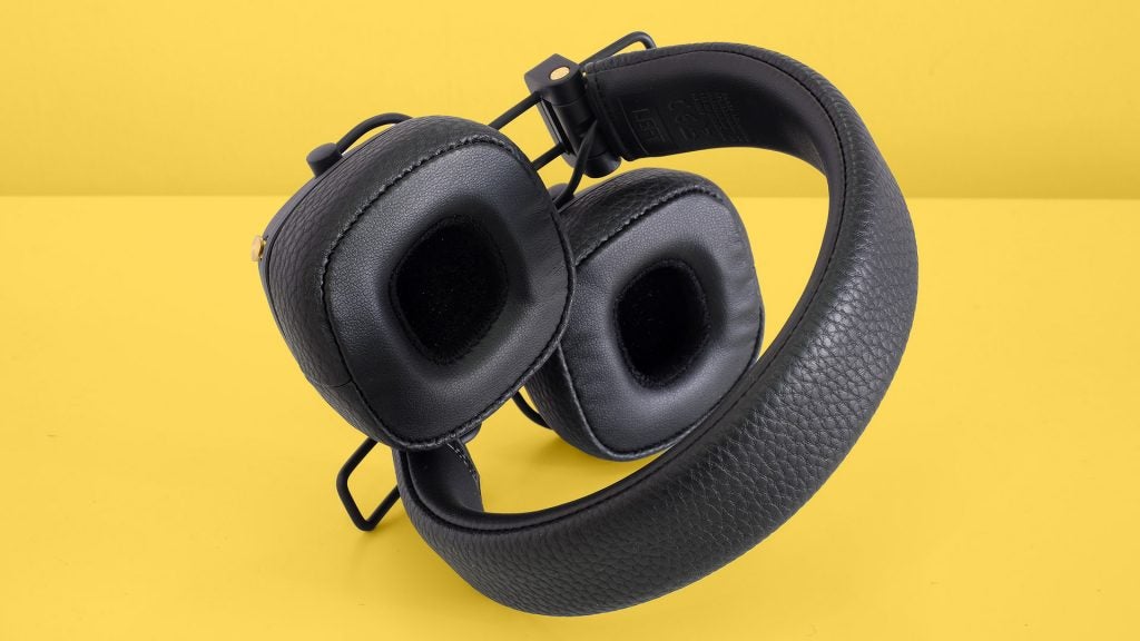 Marshall Major III VoiceBack view of black Marshal headphones kept on yellow table, earcups inside view and handband