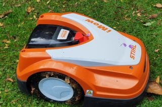 Picture of an orange-white iMow robotic lawn mover standing in a lawn