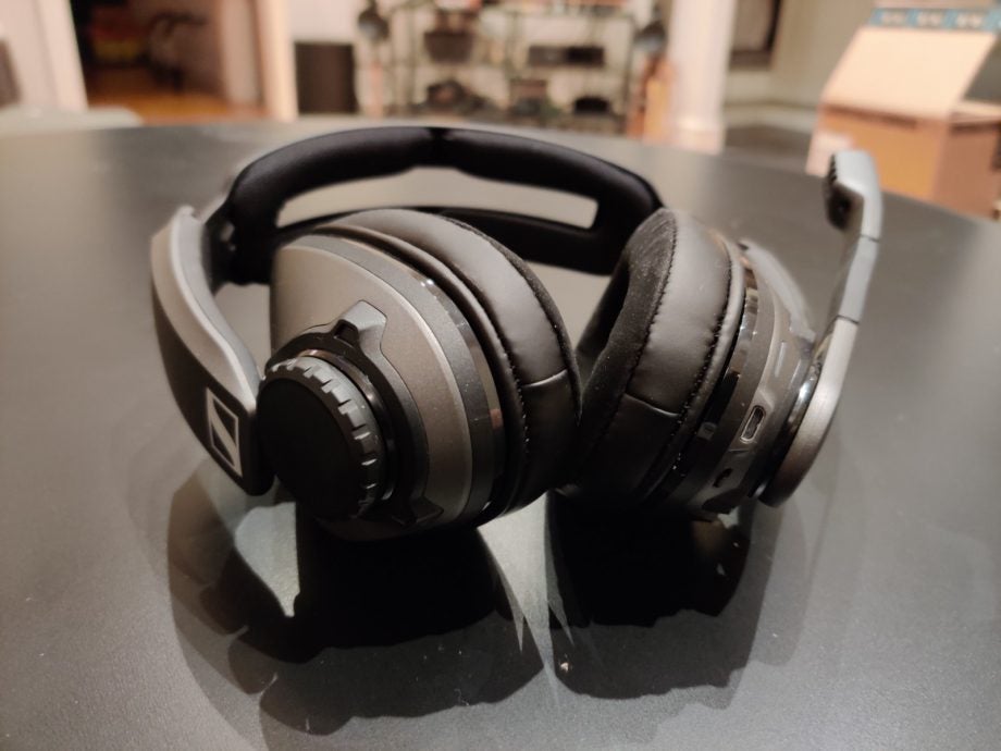 A picture of black headphones with mic kept on a black table