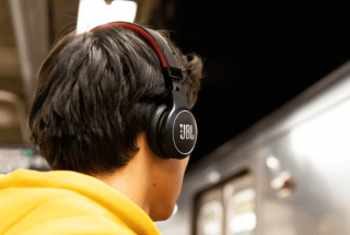 A picture of a man wearing black JBL headphones
