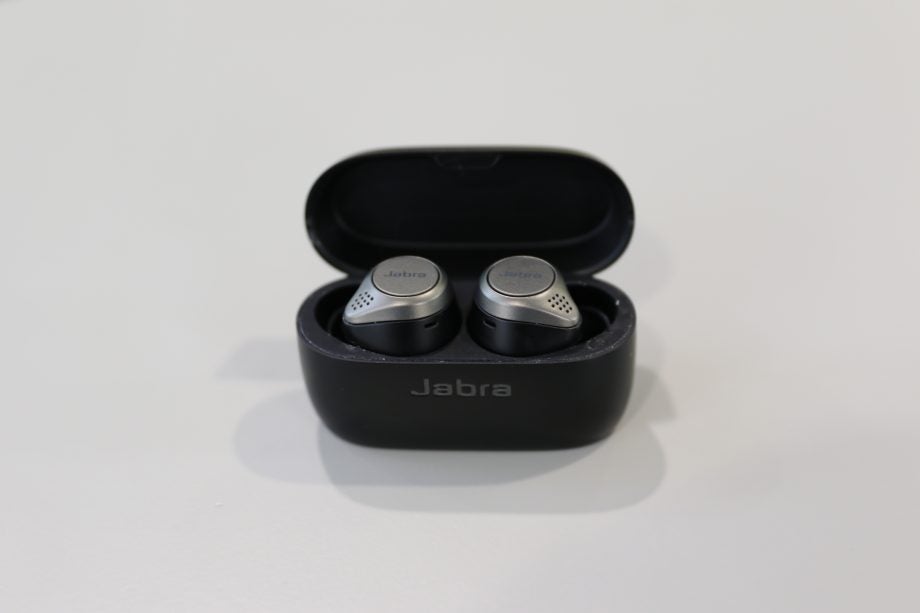 A picture of silver-black Jabra Elite 75T earbuds placed in it's case on a table