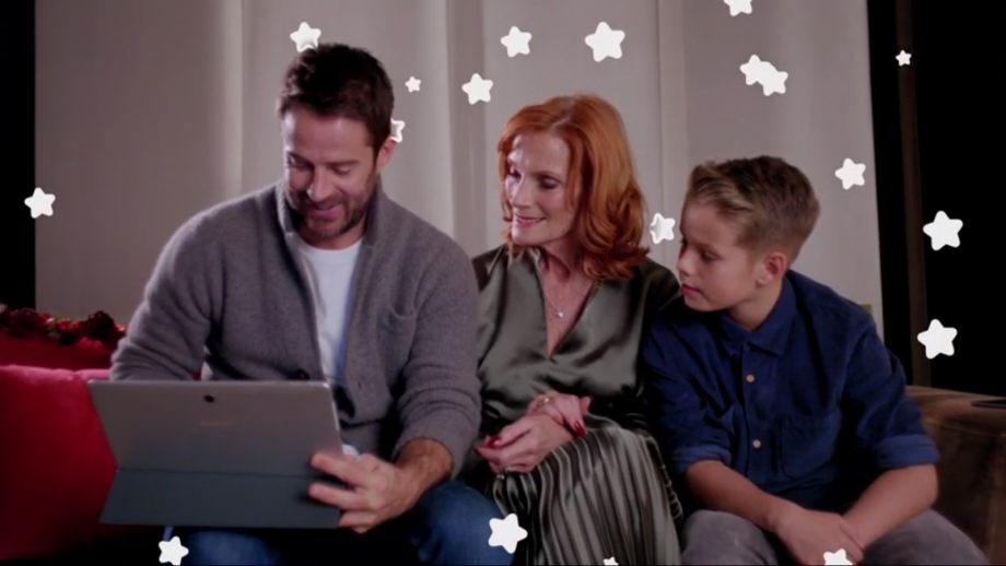 Jamie Redknapp sitting on a couch with a mother and a son, using laptop