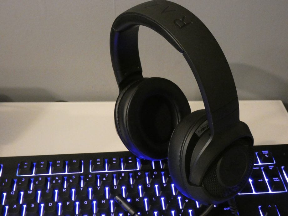 A picture of black Kraken X Lite headphones with mic standing on a keyboard