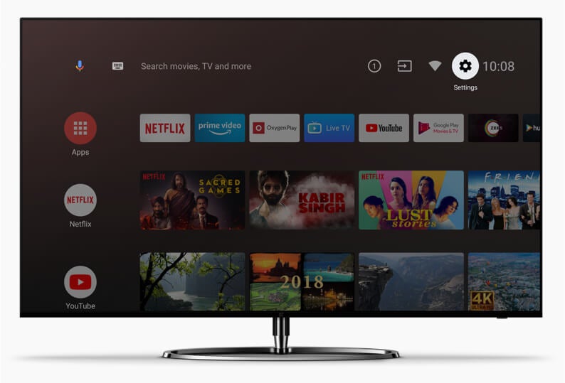 A picture of a silver-black One Plus TV standing on white background displaying Android TV's homescreen