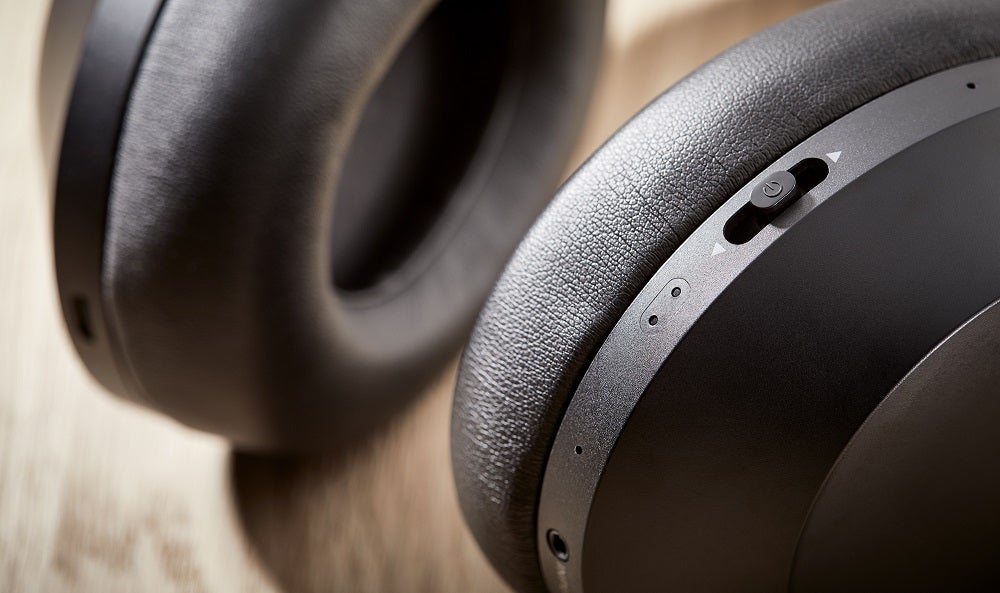 Close up picture of buttons on earcups of black Philips PH805 headphones