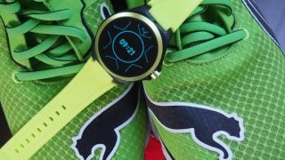Picture of a green-black Puma smartwatch kept on shoe displaying time
