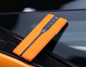 Picture of an orange-black One Plus smartphone placed facing down on a black background