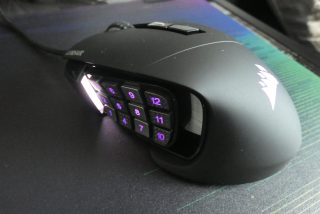 Side view of a black Corsair RGB Elite mouse kept on a table, 1 to 12 number butons on left side