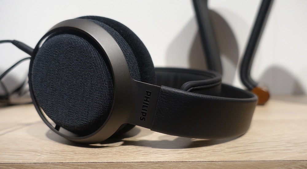 Side view of silver-black Fidelio X3 headphones laid on a wooden table