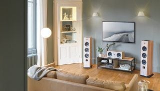 Picture of a living room with Focal Chora Lightwood speakers arranged in front of a TV mounted to a wall
