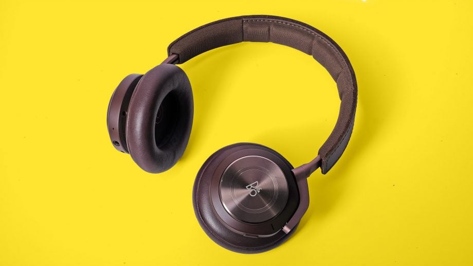 View from top of black B&O headphones kept on a yellow background