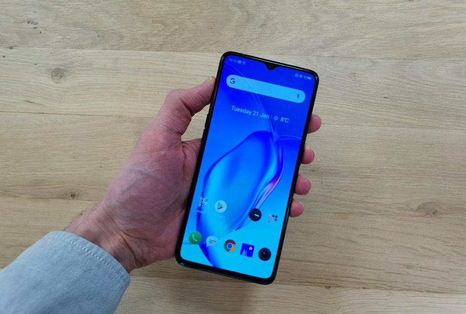 A Realme X2 Pro held in hand displaying homescreen