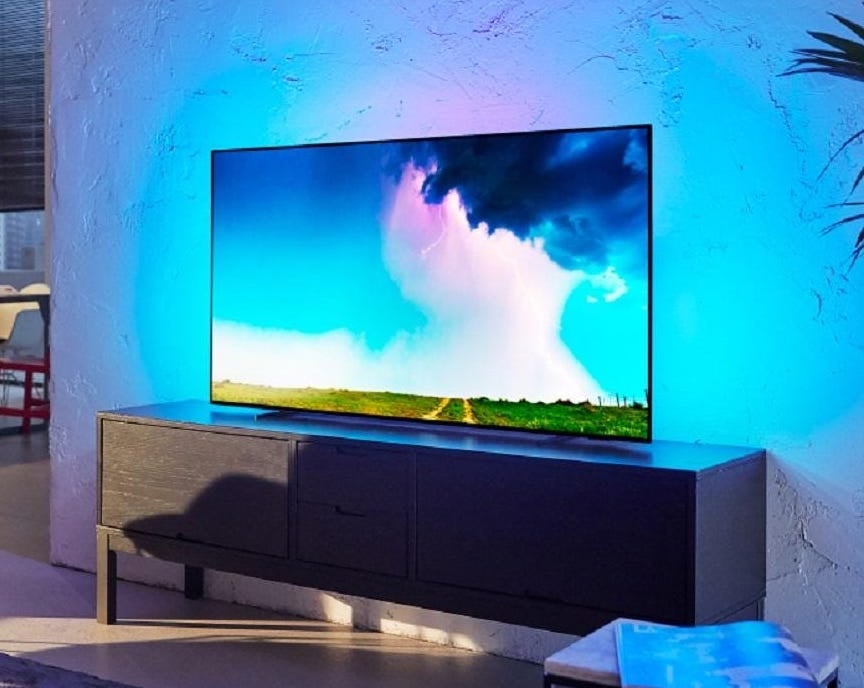 A silver Philips OLED745 TV standing on a table in a living room
